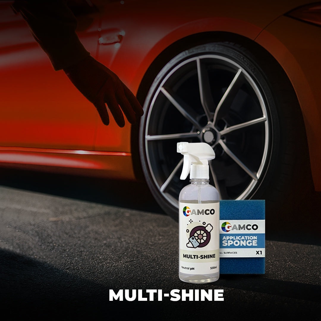 GAMCO Multi-Shine restorer spray bottle and blue applicator sponge next to a car tire and orange body panel.