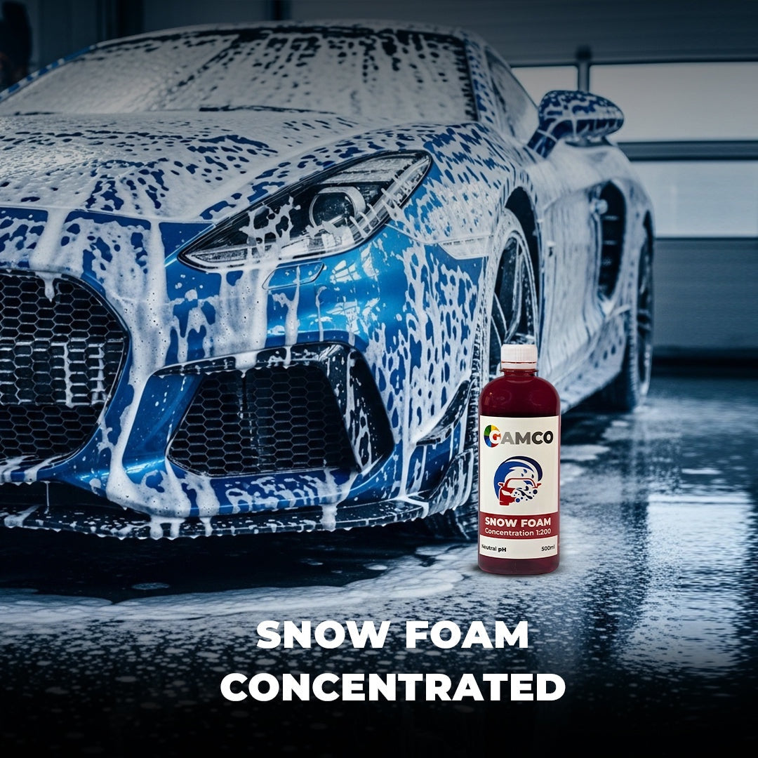 GAMCO Store Snow Foam Concentrated car wash soap bottle next to a blue sports car covered in thick foam.