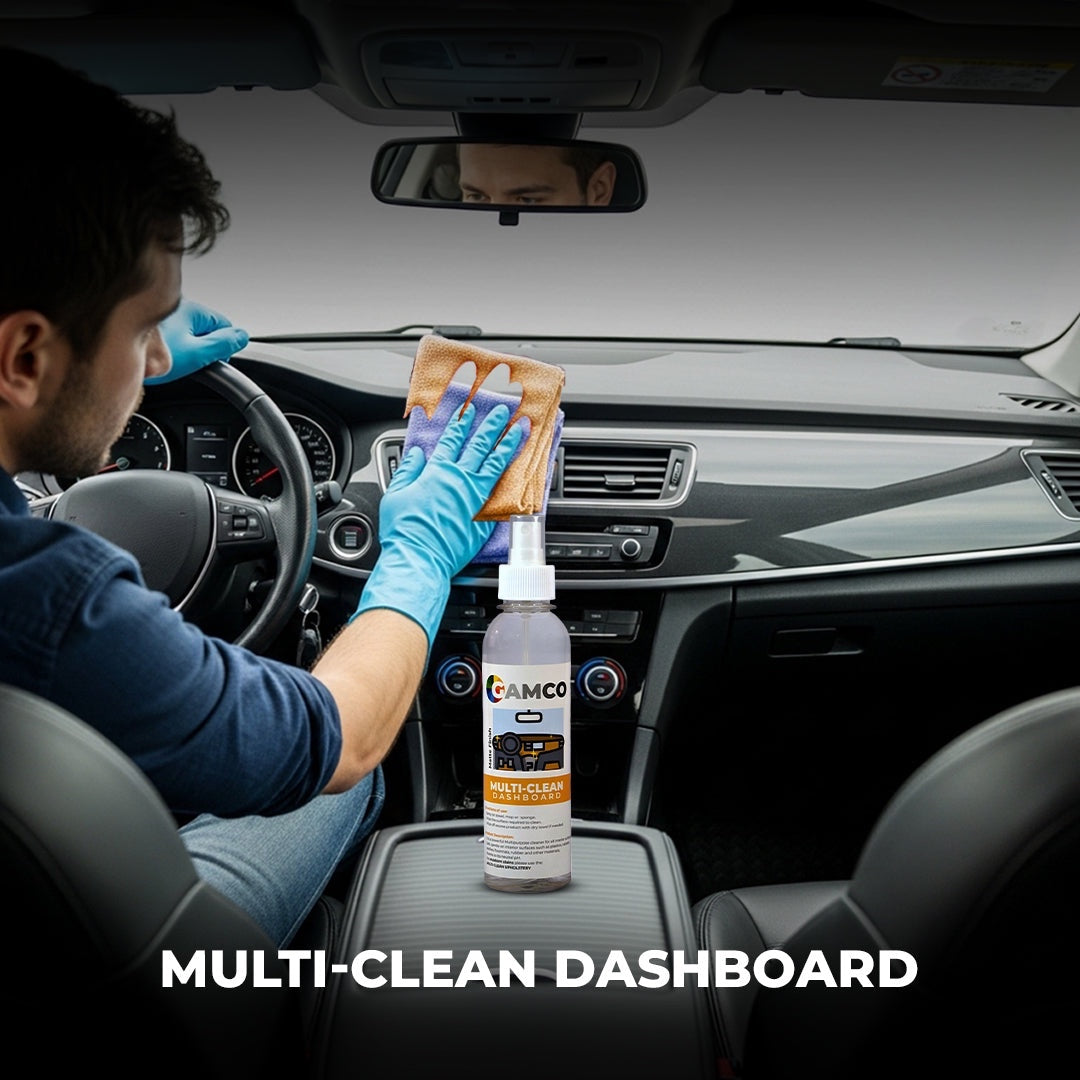 GAMCO Store Multi-Clean Dashboard cleaner being used by a person in blue gloves to wipe down a car's interior dashboard with a microfiber cloth.