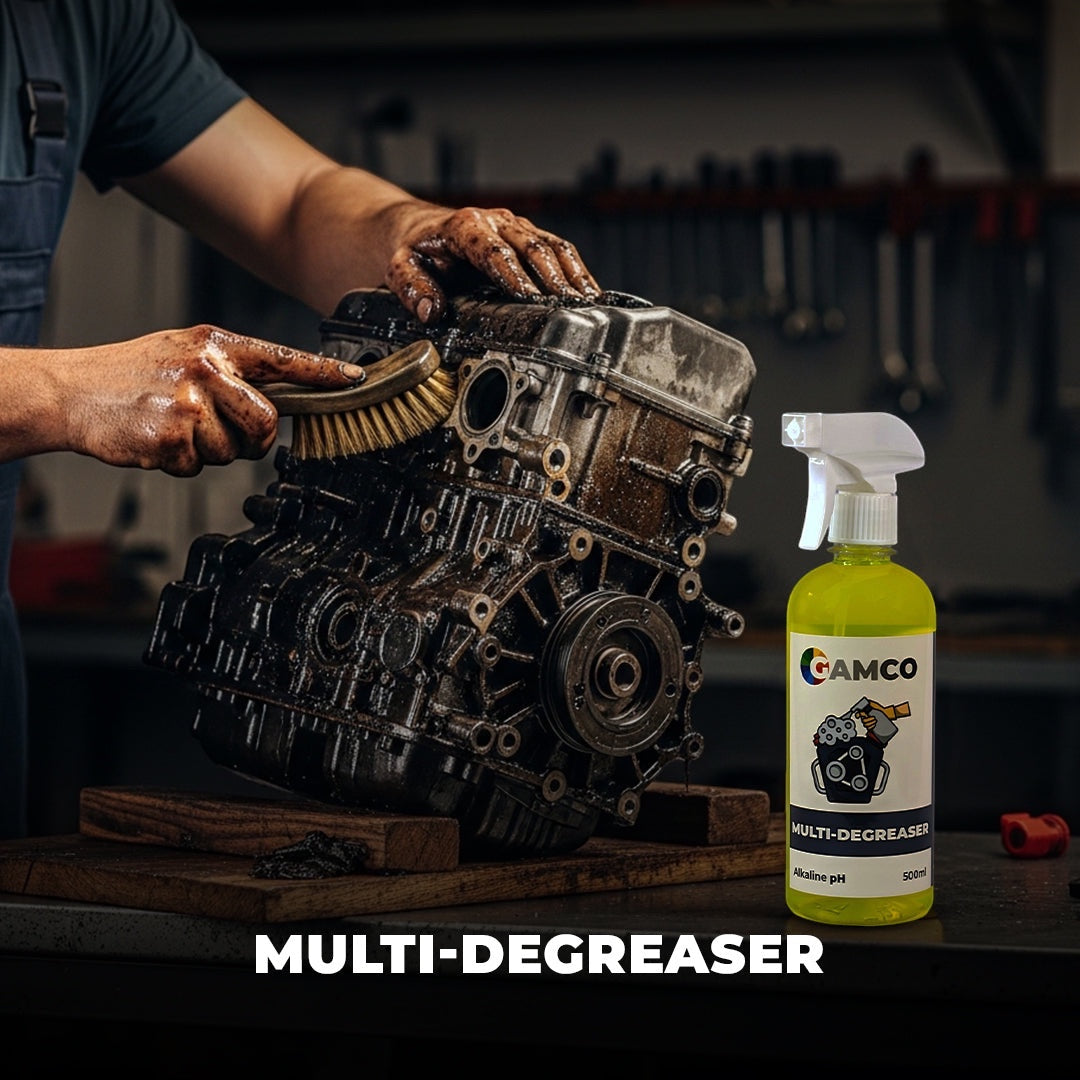 GAMCO Store Multi-Degreaser spray bottle next to a greasy engine block being cleaned with a brush.